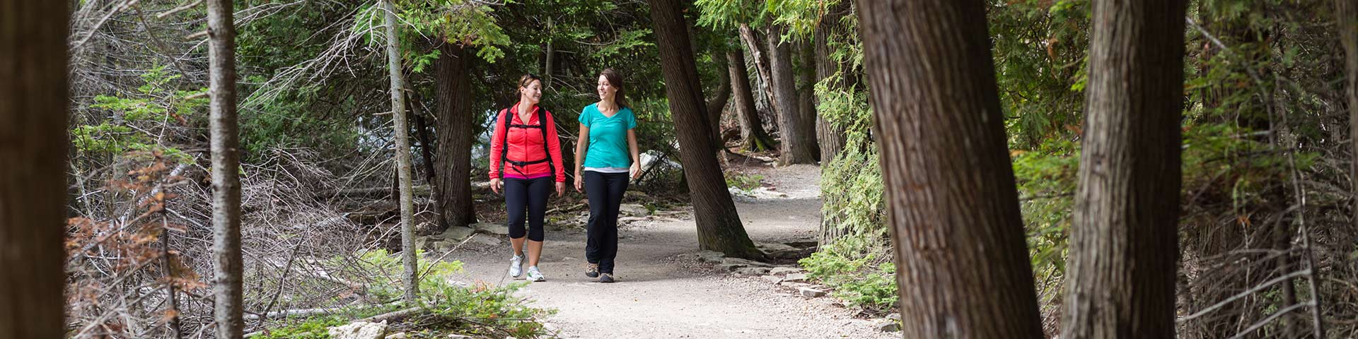 Two women hike through a forest