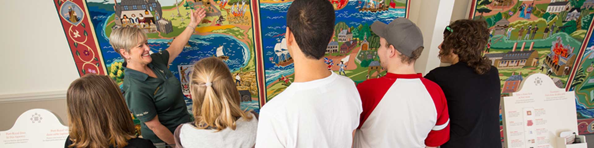 De jeunes visiteurs en apprennent plus sur la tapisserie murale.