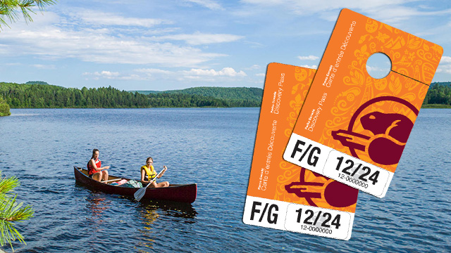 Two people in a canoe on a lake on a beautiful summer day. A Parks Canada 2024 Discovery Pass image is displayed in the foreground.