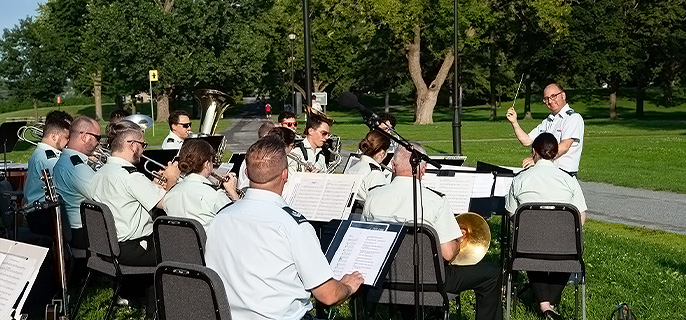 The conductor and musicians of the Canadian Forces Leadership and Recruit School performing an outdoor concert at Fort Chambly National Historic Site.