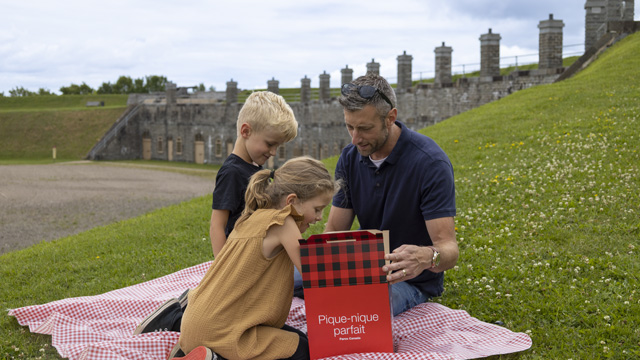 A father with his two children prepare to enjoy a picnic at Fort No.1.