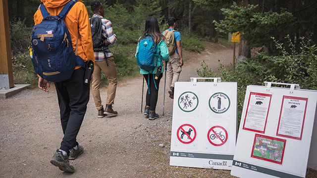 hikers on trail passing seasonal closure signs