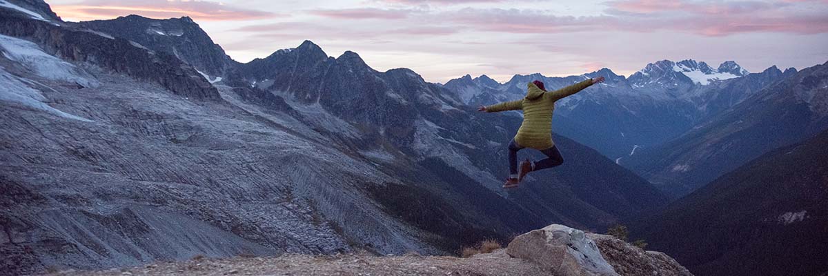 Person jumping in front of mountain sunset