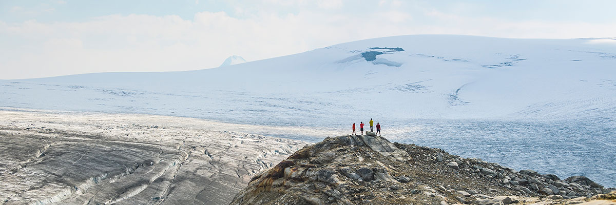 Four people standing in front of a glacier