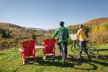 Two cyclists take a break to observe the fall landscape