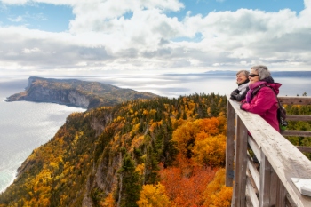 Two tourists enjoy the autumn landscape from the top of a tower 