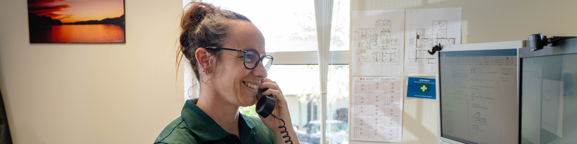 Parks Canada employee on the phone in an office. 