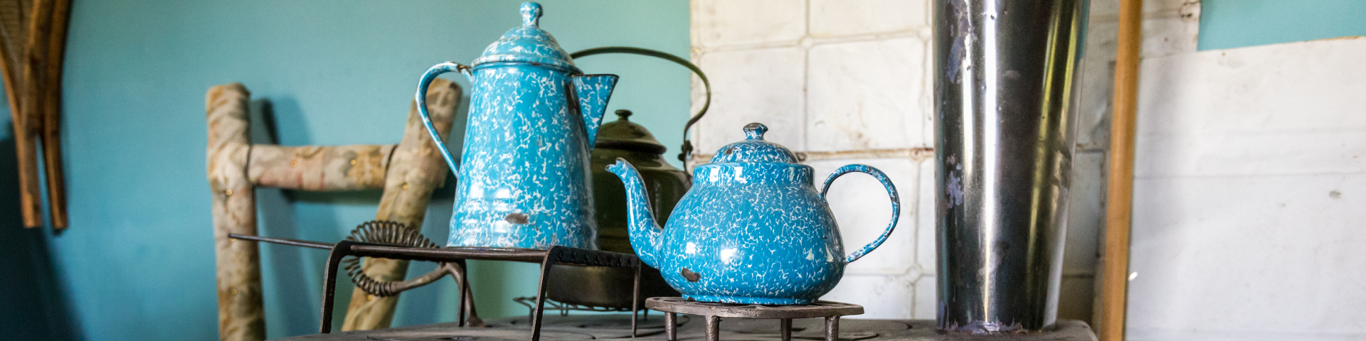  A stove with a coffee pot and tea pot in the Robert Service Cabin, Dawson Historical Complex National Historic Site