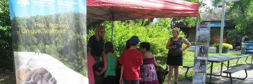 Des enfants sous une tente-abri d’un kiosque d’exposition.