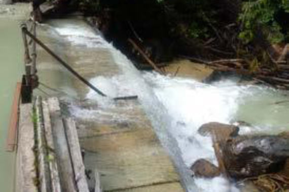 Une barrière en béton (déversoir) et de l’eau coulant sur le dessus.