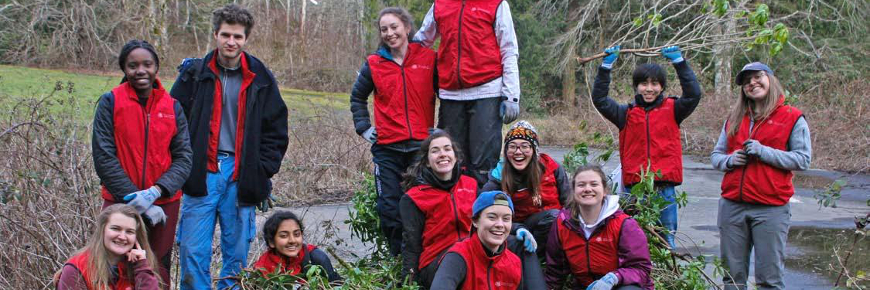 Photo de groupe de jeunes entourés de végétation coupée.