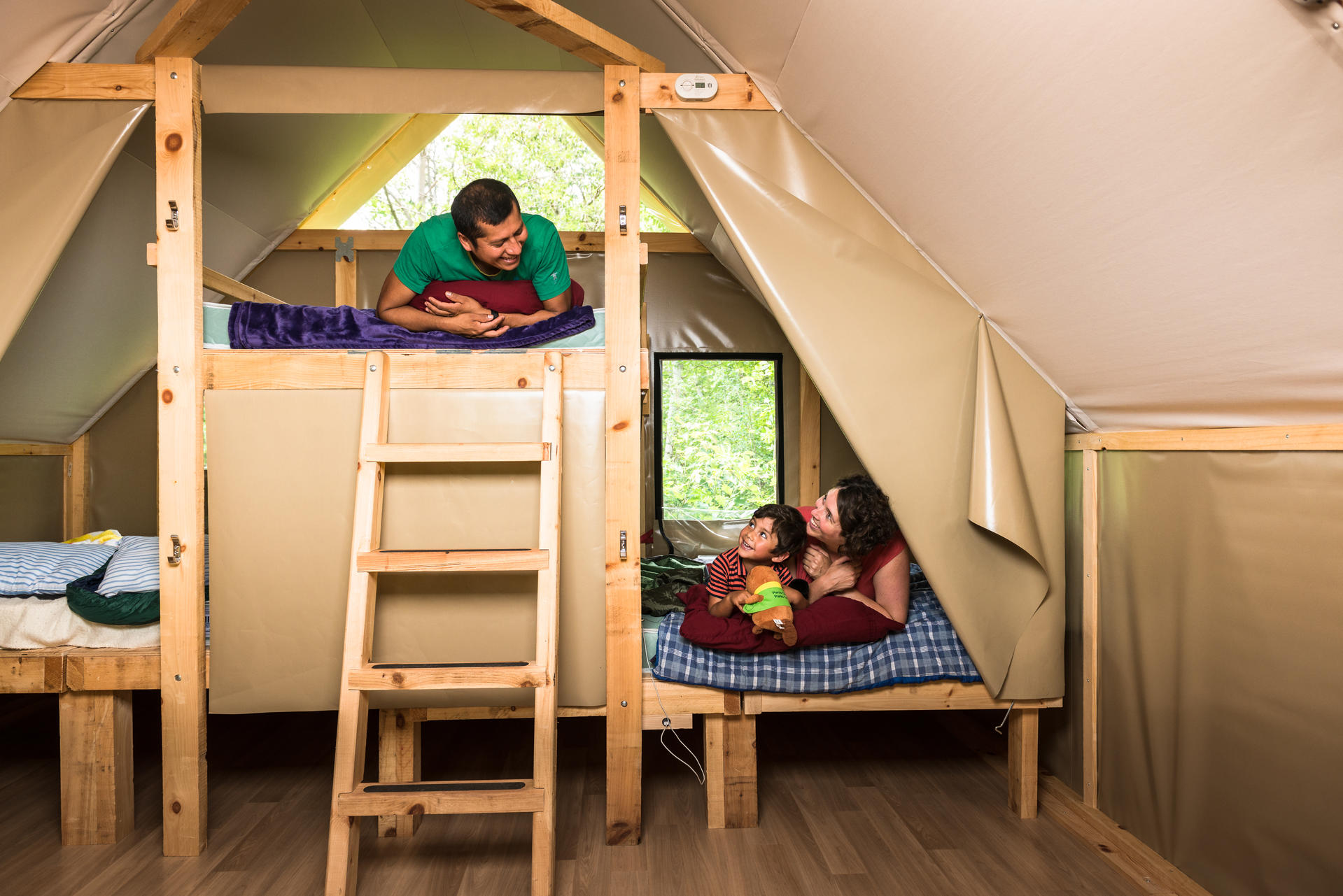 A family enjoying their stay in an oTENTik at Cheticamp Campground, Cape Breton Highlands National Park.