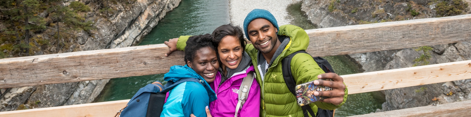 A group of millennials take a selfie while hiking on the Lake Minnewanka Trail.