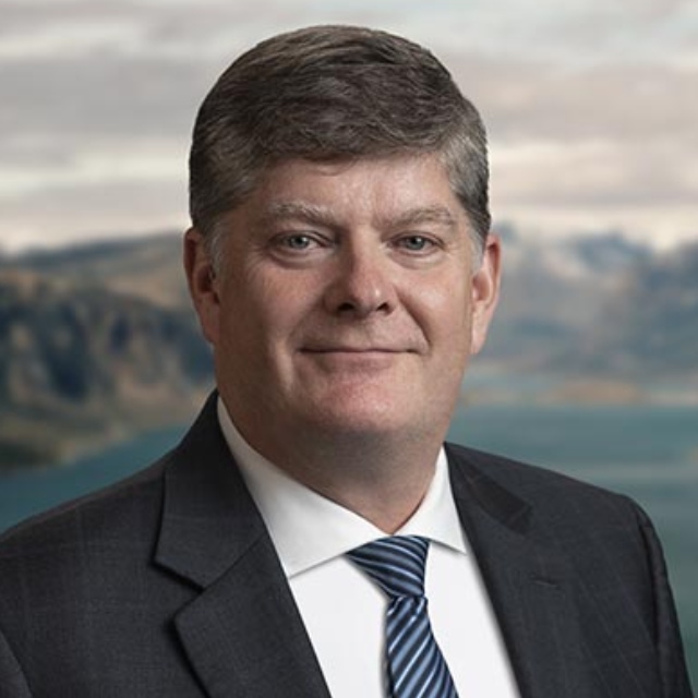 Headshot of Parks Canada President and CEO Ron Hallman. He has blue eyes and gray hair and is wearing a suit and tie.