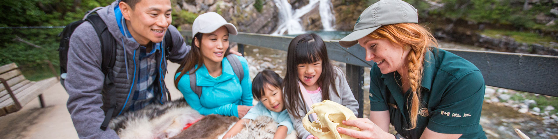 A Parks Canada interpreter engages a young family at Waterton Lakes National Park.