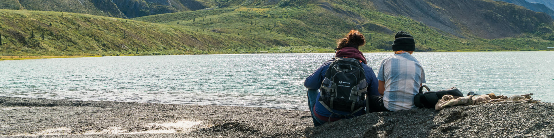 Two Sahtu youth sit on the shores of Níonep’eneɂ Tué (Grizzly Bear Lake) in Nááts'ihch'oh National Park Reserve, Northwest Territories.