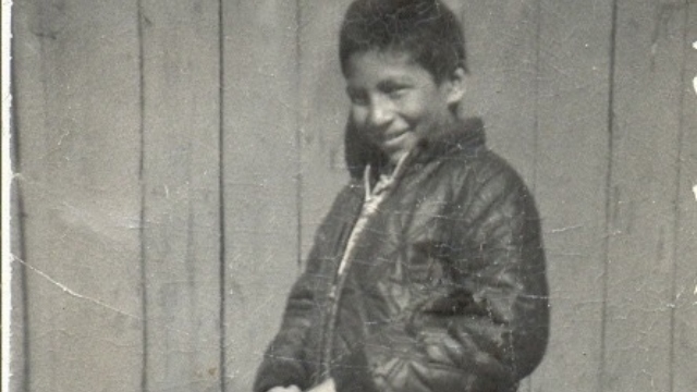 Personnage historique national de Chanie Wenjack (1954-1966), un enfant debout devant un mur, vers 1965