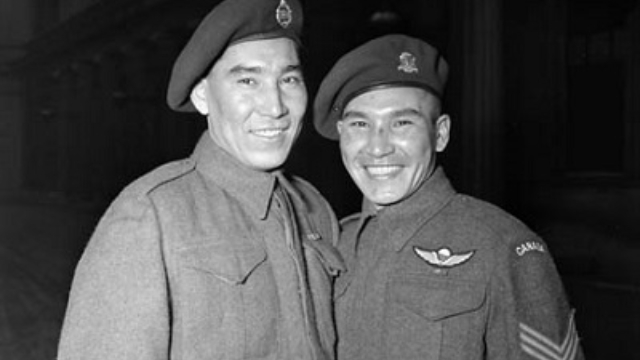 Deux hommes en uniforme militaire sourient à la caméra