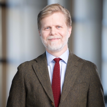 A man dressed in a jacket and tie is standing