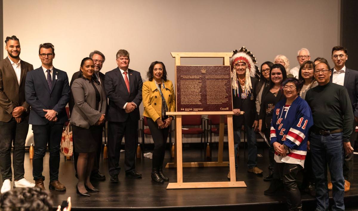 Group gathered around commemorative plaque for Breaking Racial Barriers in the National Hockey League National Historic Event, Hockey Hall of Fame, Toronto