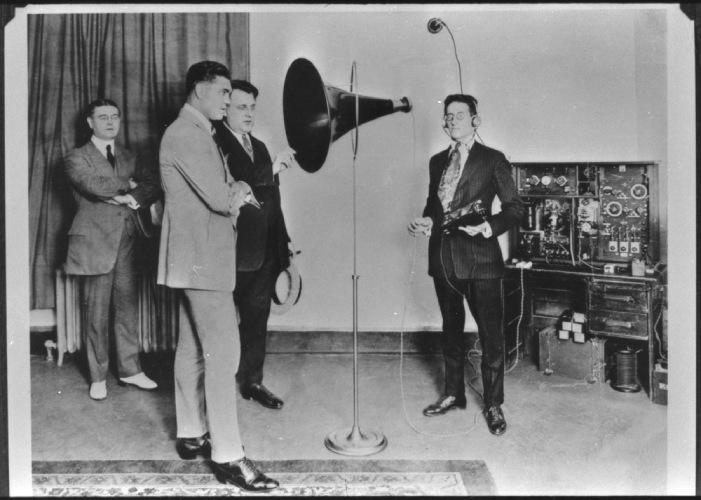 Man speaks in a microphone from early radio broadcasting