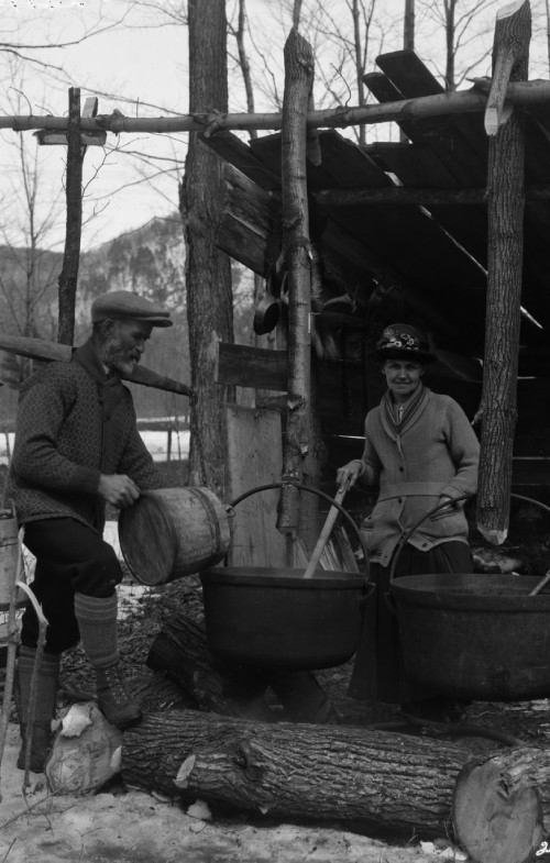 Two persons boiling maple sap in maple sugar bush, 1926