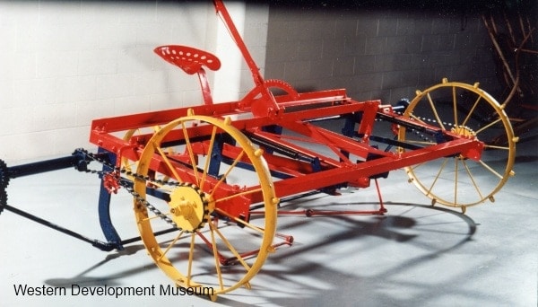 A red and yellow metallic agriculture machine on display