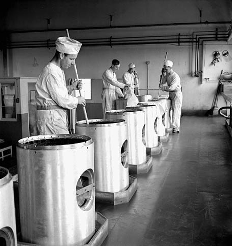 Workmen stirring chemicals used in the manufacture of warheads at Defence Industries Limited, 1944