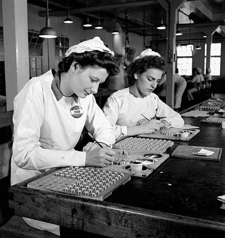 Two workers at the Defense Industries Limited factories show discing detonator pellets for missiles, Ajax, 1944