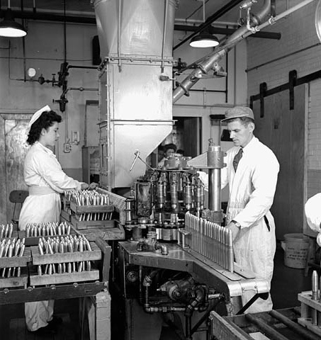 Two workers fill 20 milimeters shells at Defence Industries Limited, 1944