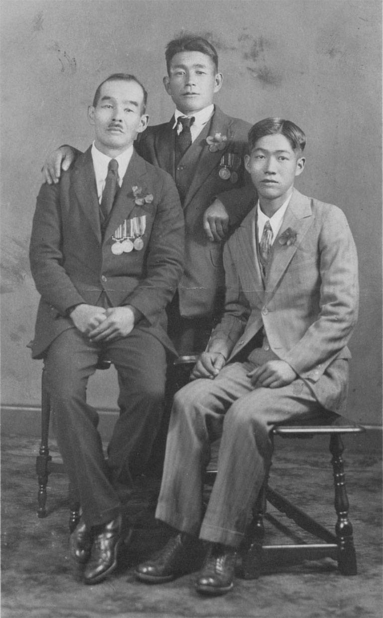 Photo en noir et blanc de trois hommes posant pour la caméra