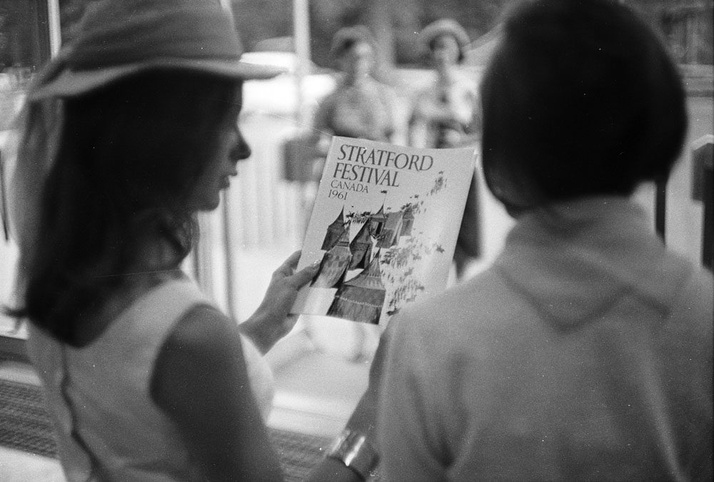Black and white image of a woman holding a pamphlet