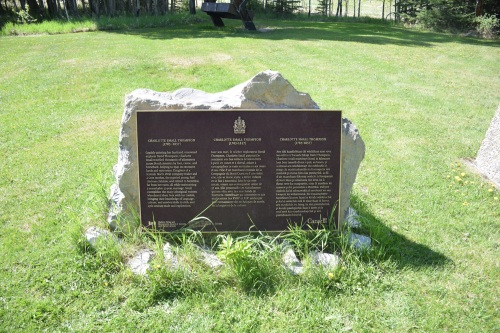 Plaque commémorative en bronze sur son socle dans l'herbe