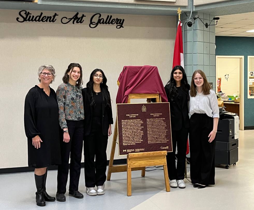 Groupe de personnes debout à côté d'une plaque commémorative pour le personnage historique national d'Ethel Catherwood