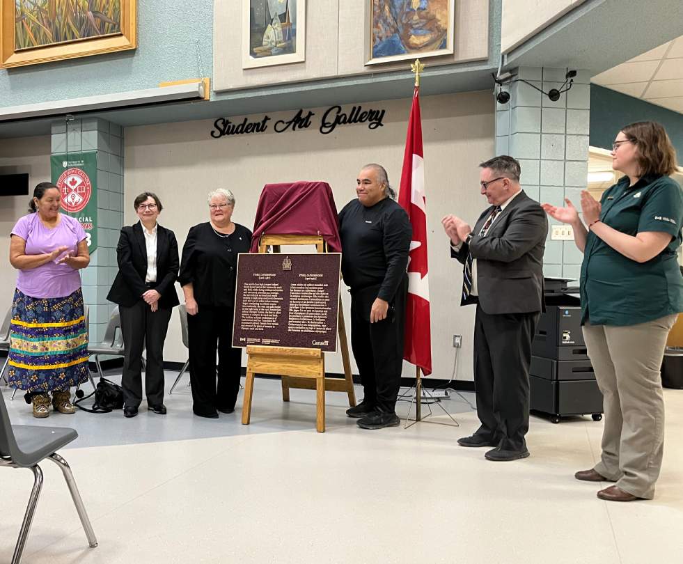 Groupe de personnes debout à côté d'une plaque commémorative pour le personnage historique national d'Ethel Catherwood
