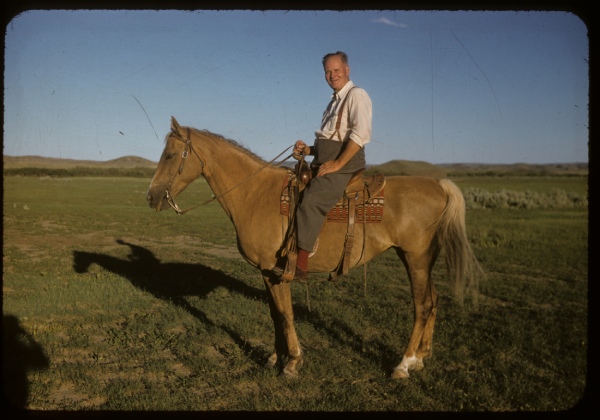 Un homme monte à cheval tout sourire avec un ciel bleu