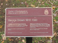 A commemorative bronze plaque installed near grass