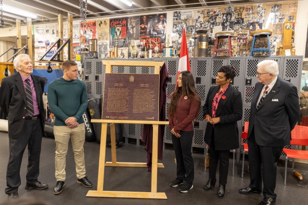 A group of people standing beside a commemorative plaque