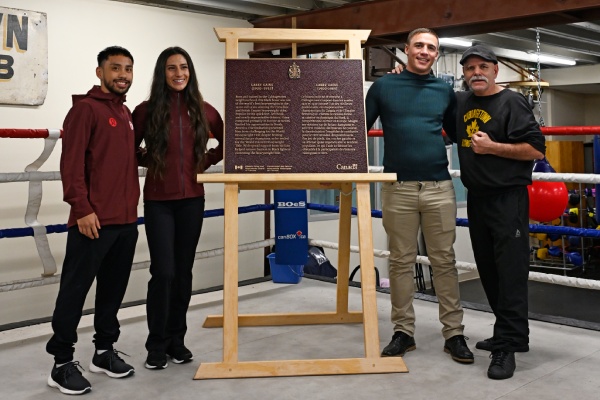 Un groupe de personnes debout près d'une plaque commémorative