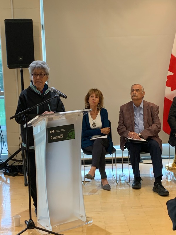 Une femme devant un lutrin adresse un discours lors d'un événement officiel