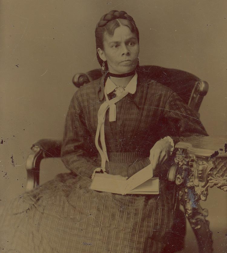 A woman, seated with a book