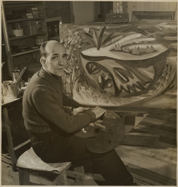 Paul-Émile Borduas seated in front of an art piece, 1946