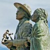 Statues of a man and woman on a blue sky background
