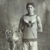 Black and white photo of a man posing next to a trophee