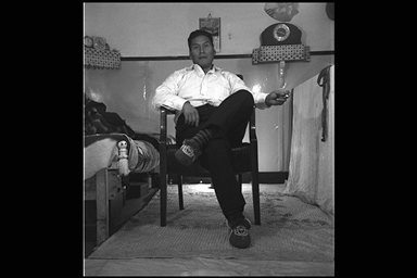 Image en noir et blanc d'un homme assis sur une chaise