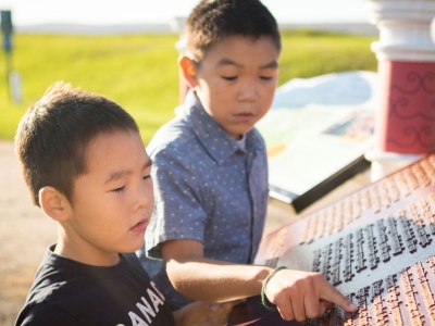 Two kids reading a commemorative bronze plaque