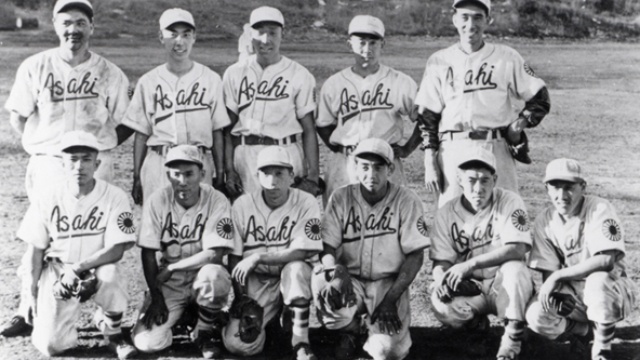 Photo en noir et blanc d'une équipe de baseball avec le mot Asahi écrit sur le chandail de chaque membre