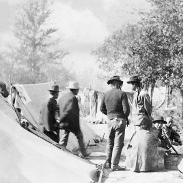 Photo en noir et blanc de travailleurs sur leur site de campement