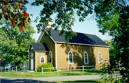 Yellow church surrounded by greenery