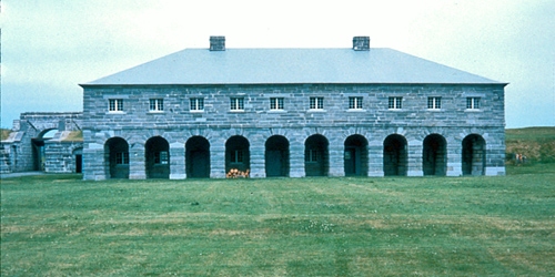 Front facade of Fort Lennox National Historic Site with eight arches and windows above each arch